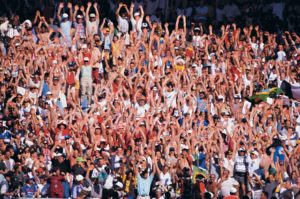 A large crowd of people raising their arms