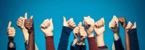 Hands doing thumbs-up gesture against blue background